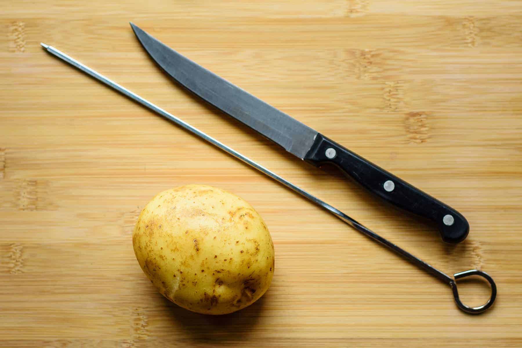 View of knife and skewer with potato