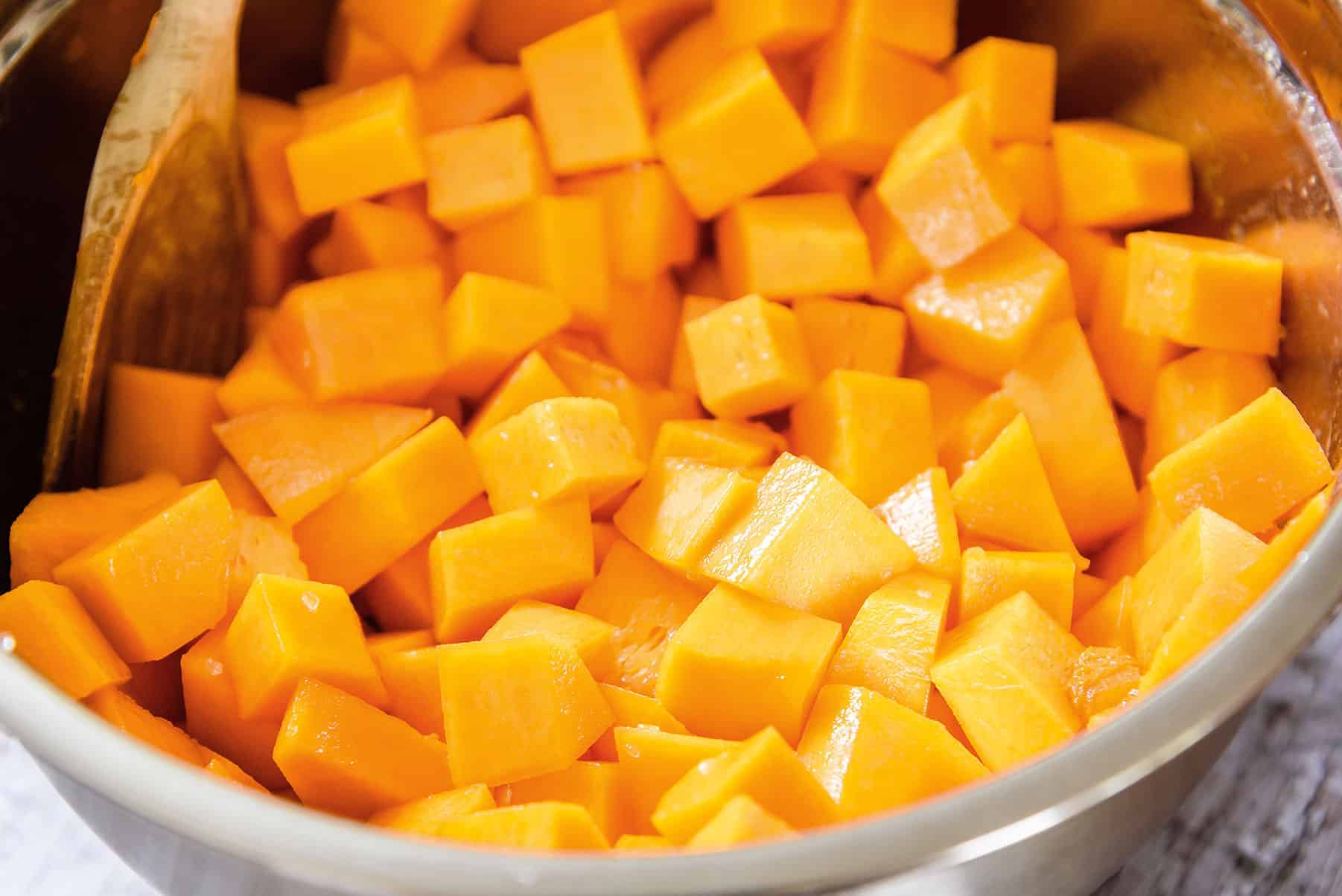 Adding diced butternut squash to melted butter