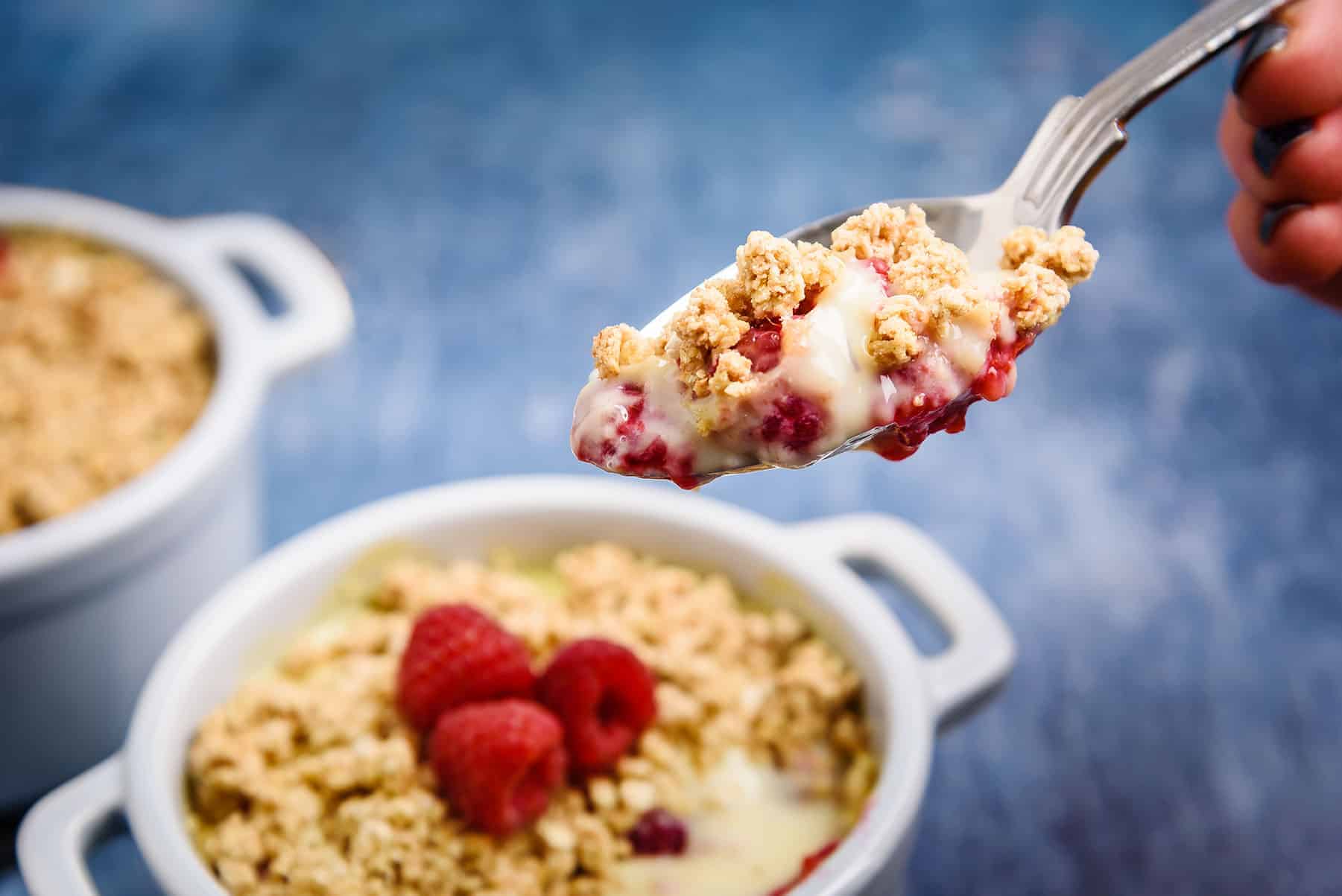 Close up of Vegan Fruit Custard Crumble with Raspberries on Spoon