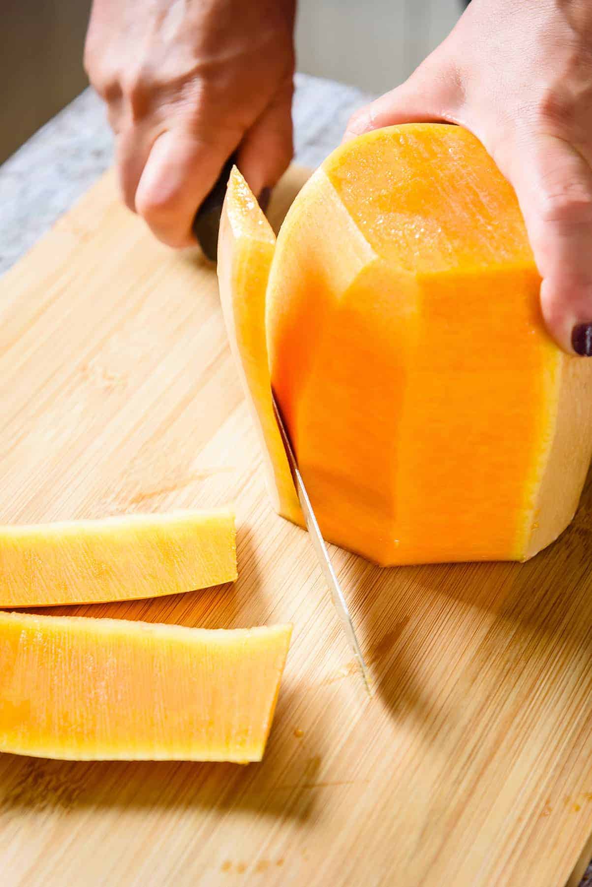 Cutting the peel off the sides of the squash