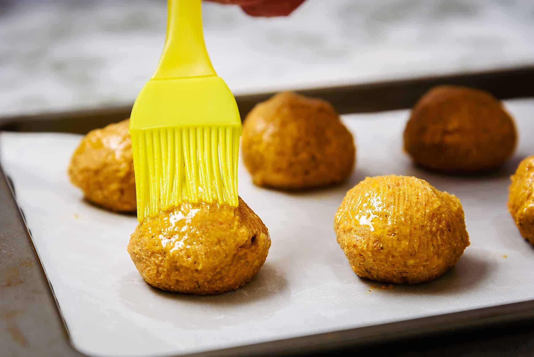 Brushing falafel balls with oil