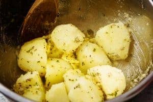 Par-boiled potatoes in butter mixture