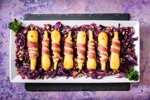 Vegan Parsnips in Blankets on a bed of cabbage with nuts