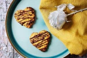 2 heart-shaped vegan oat & apricot cookies on a plate