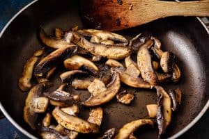 Cooked sliced mushrooms in a frying pan