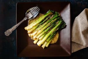 Overhead view of Baby Leeks with Wholegrain Mustard with serving spoon and fork