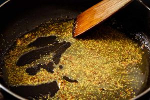 Stirring wholegrain mustard into remaining stock